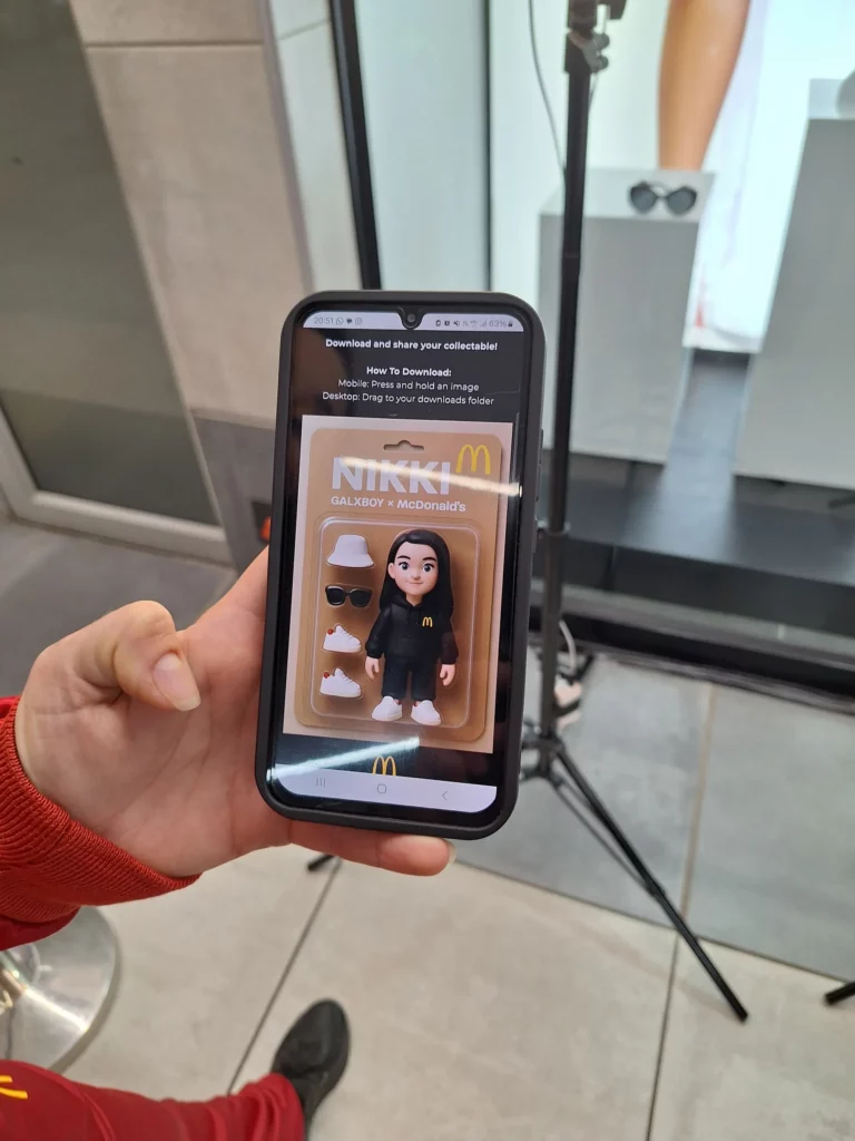 Hand holds a phone displaying a branded AI character portrait in a collectible figure style.